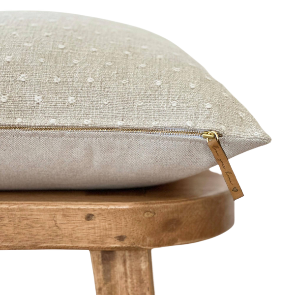a white pillow sitting on top of a wooden chair