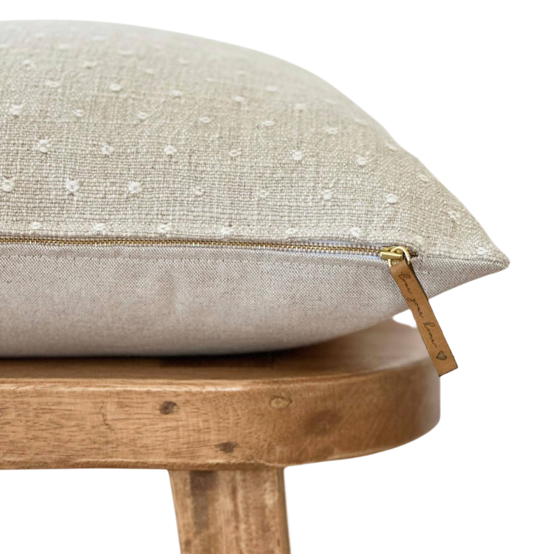 a white pillow sitting on top of a wooden chair