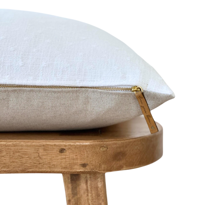 a white pillow sitting on top of a wooden chair