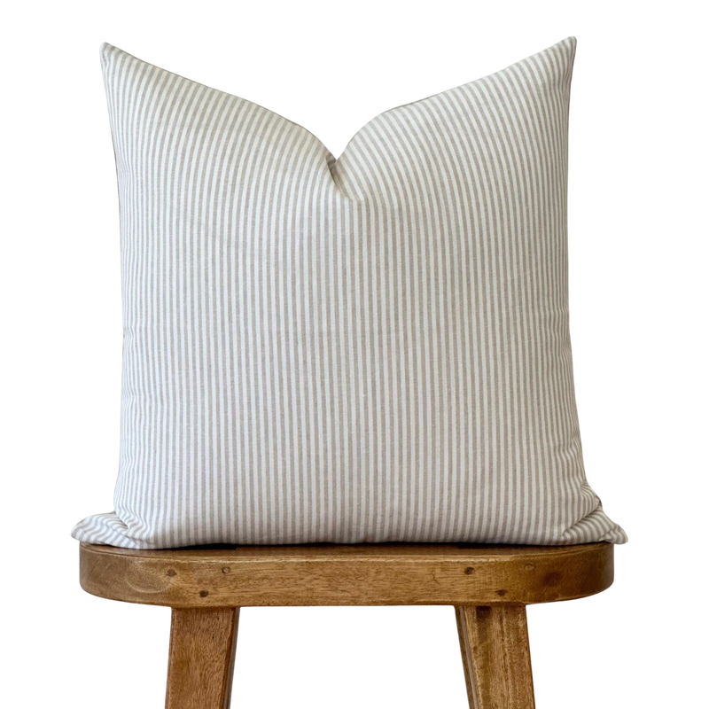 a white pillow sitting on top of a wooden chair
