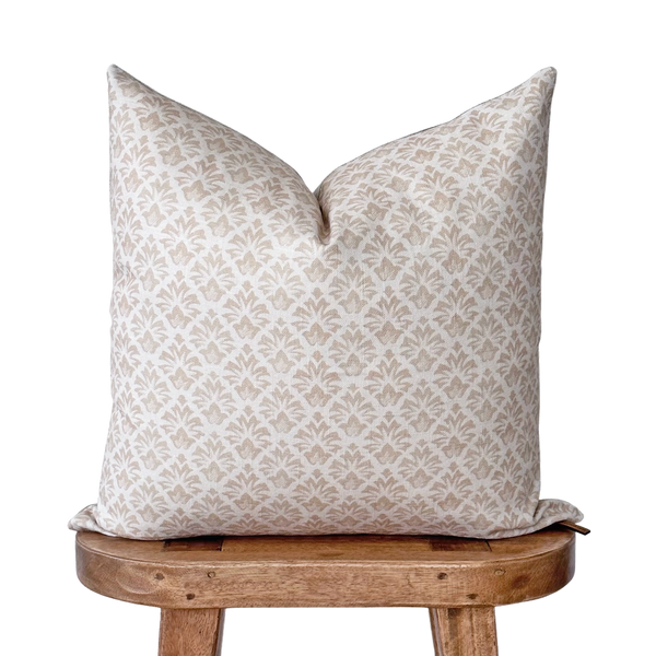 a white pillow sitting on top of a wooden chair