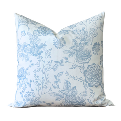 a blue and white floral pillow on a black background