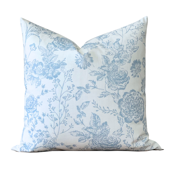 a blue and white floral pillow on a black background