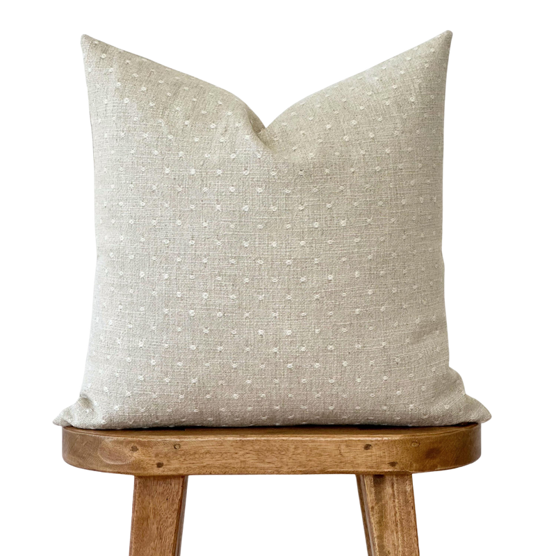 a white pillow sitting on top of a wooden chair