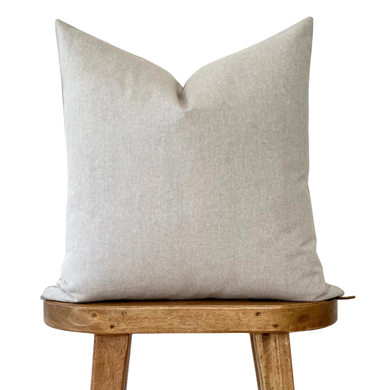 a white pillow sitting on top of a wooden chair