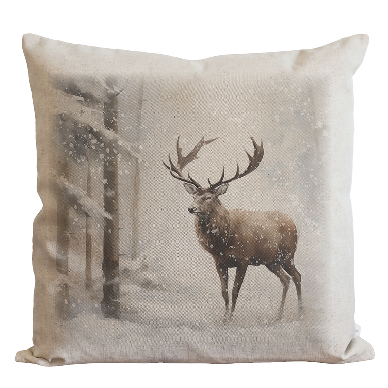 a pillow with a deer standing in the snow