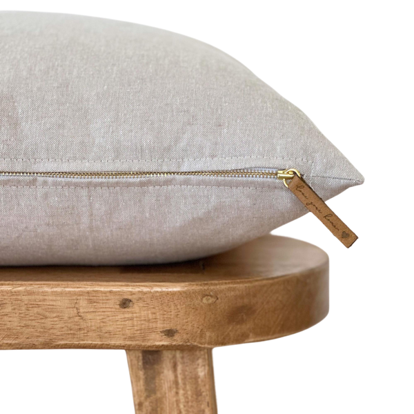 a pillow on a wooden chair with a zipper