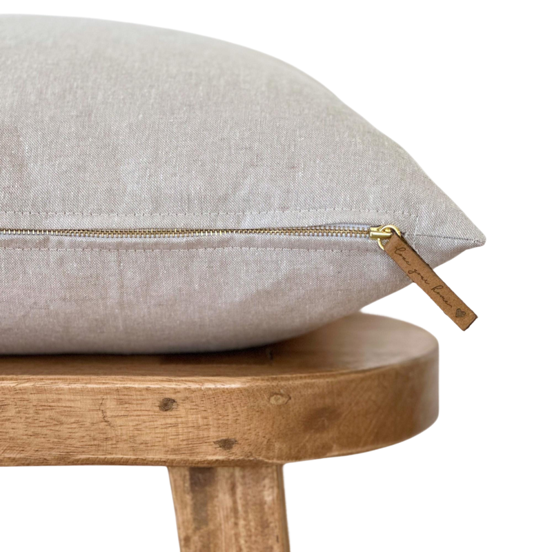 a pillow on a wooden chair with a zipper