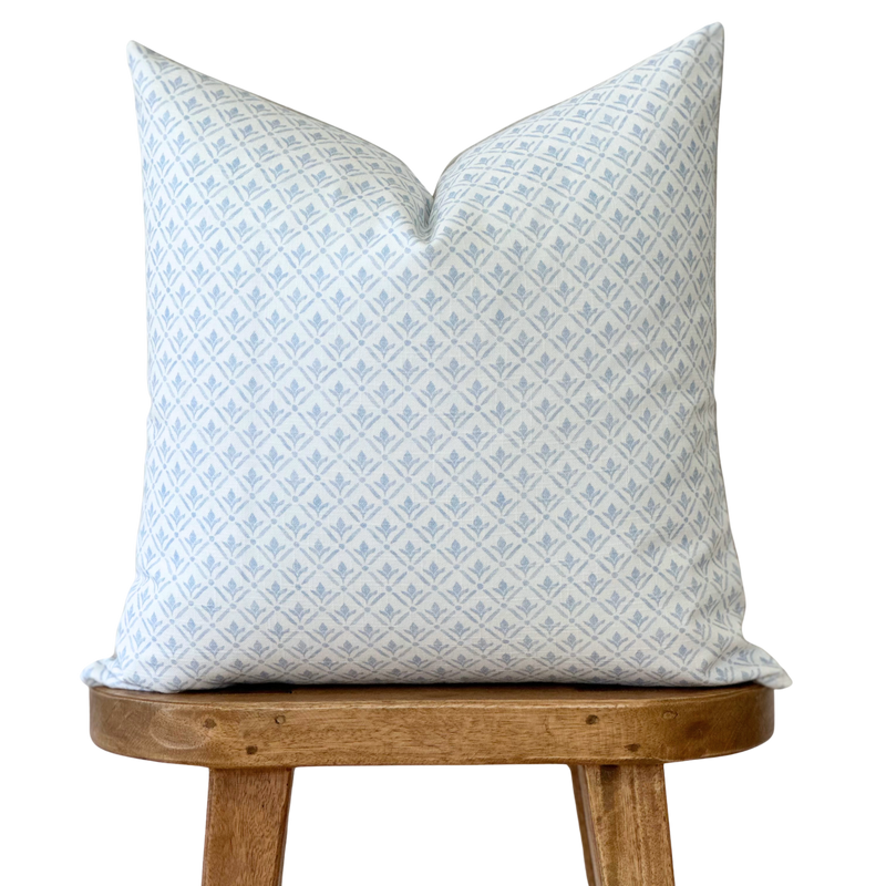 a blue and white pillow sitting on top of a wooden chair