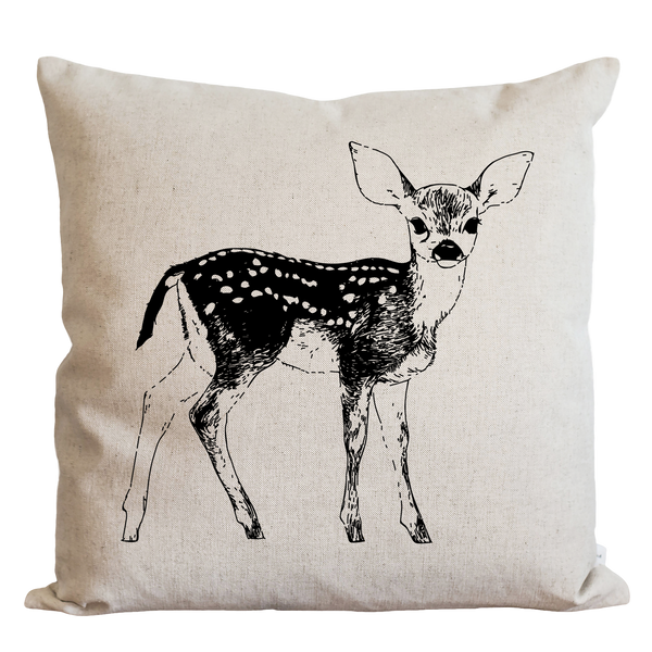 A beige pillow with a black and white illustration of a deer standing upright.