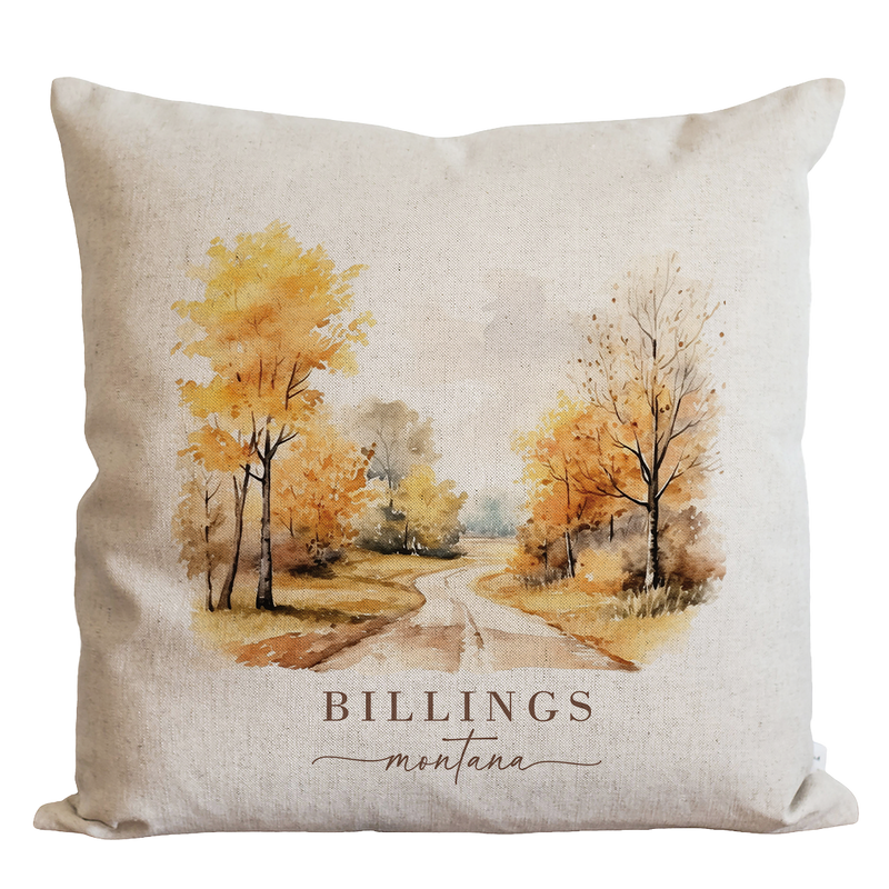 a pillow with a watercolor painting of a country road
