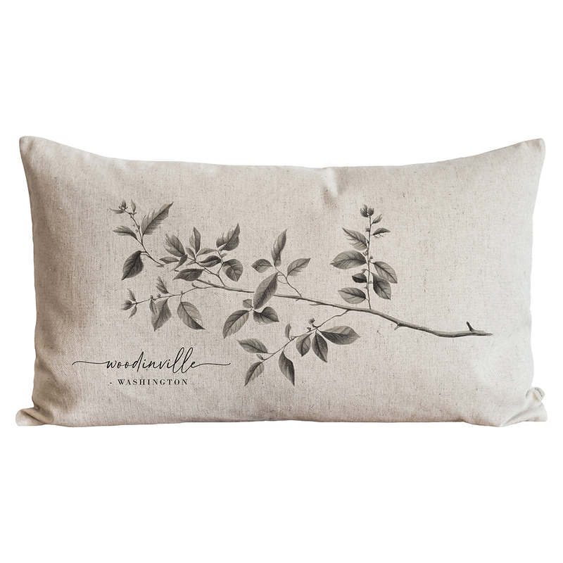 a white pillow with a branch on it