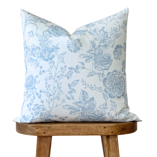 a blue and white pillow sitting on top of a wooden chair
