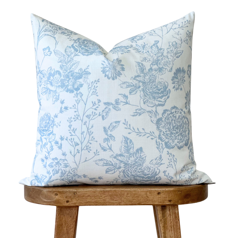 a blue and white pillow sitting on top of a wooden chair
