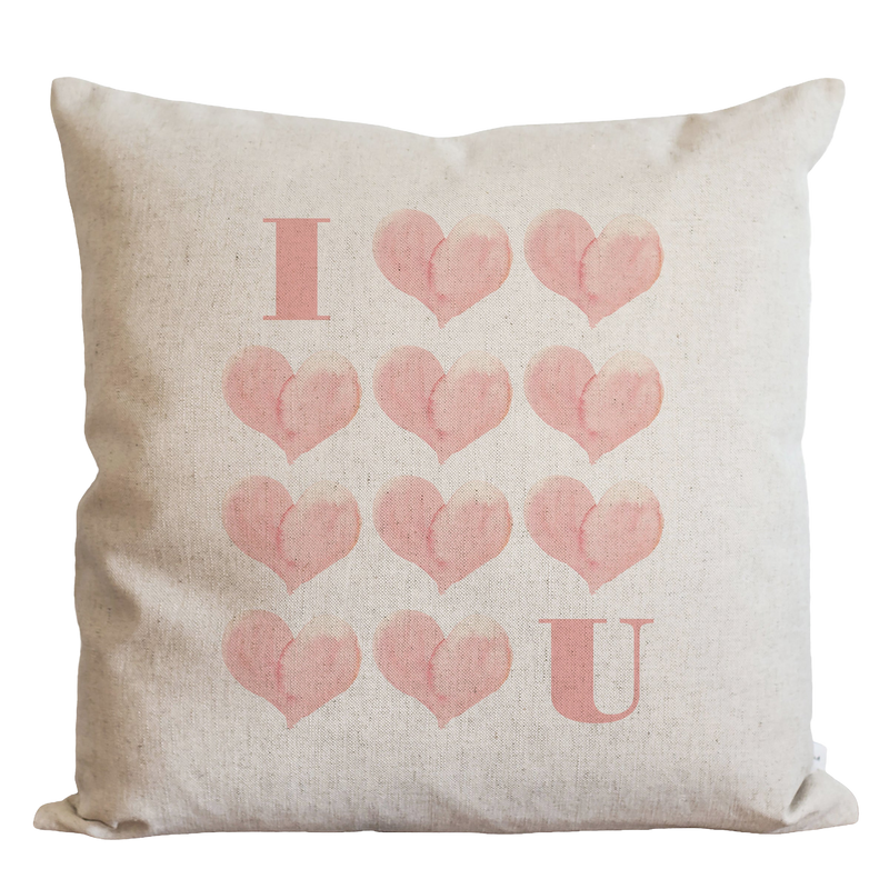 a white pillow with pink hearts on it