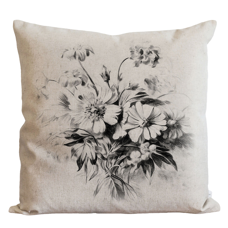 a black and white pillow with a bouquet of flowers on it