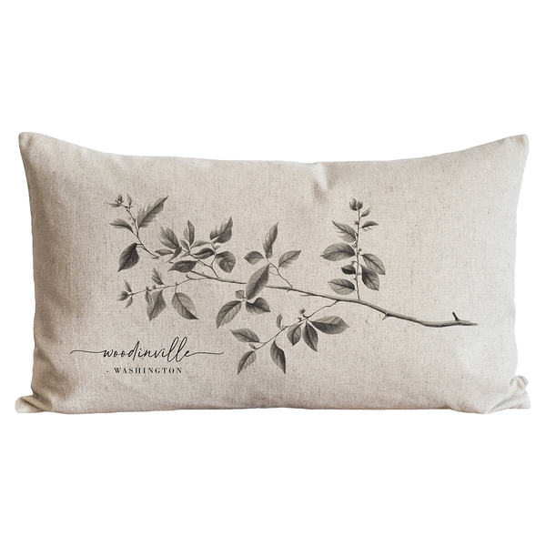 a black and white pillow with a branch on it
