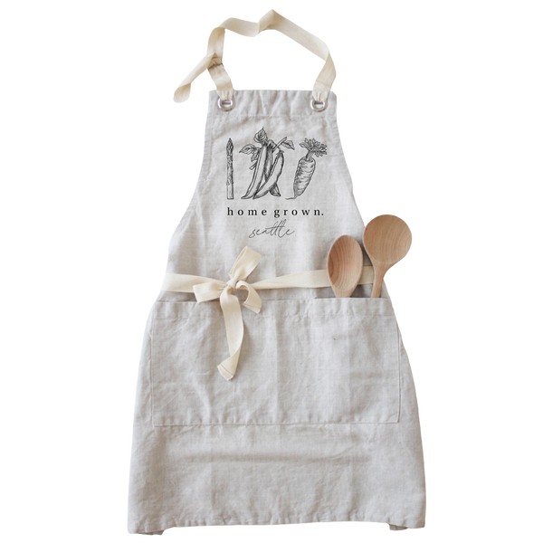 a white apron with two wooden spoons in it