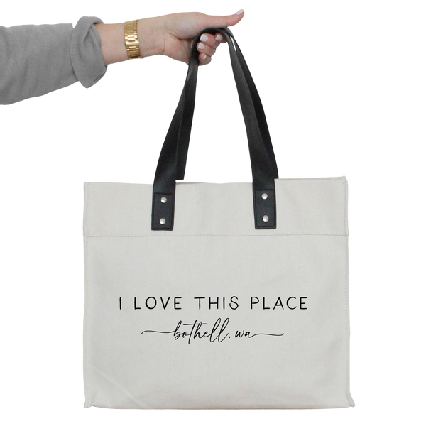a woman's hand holding a tote bag that says i love this place
